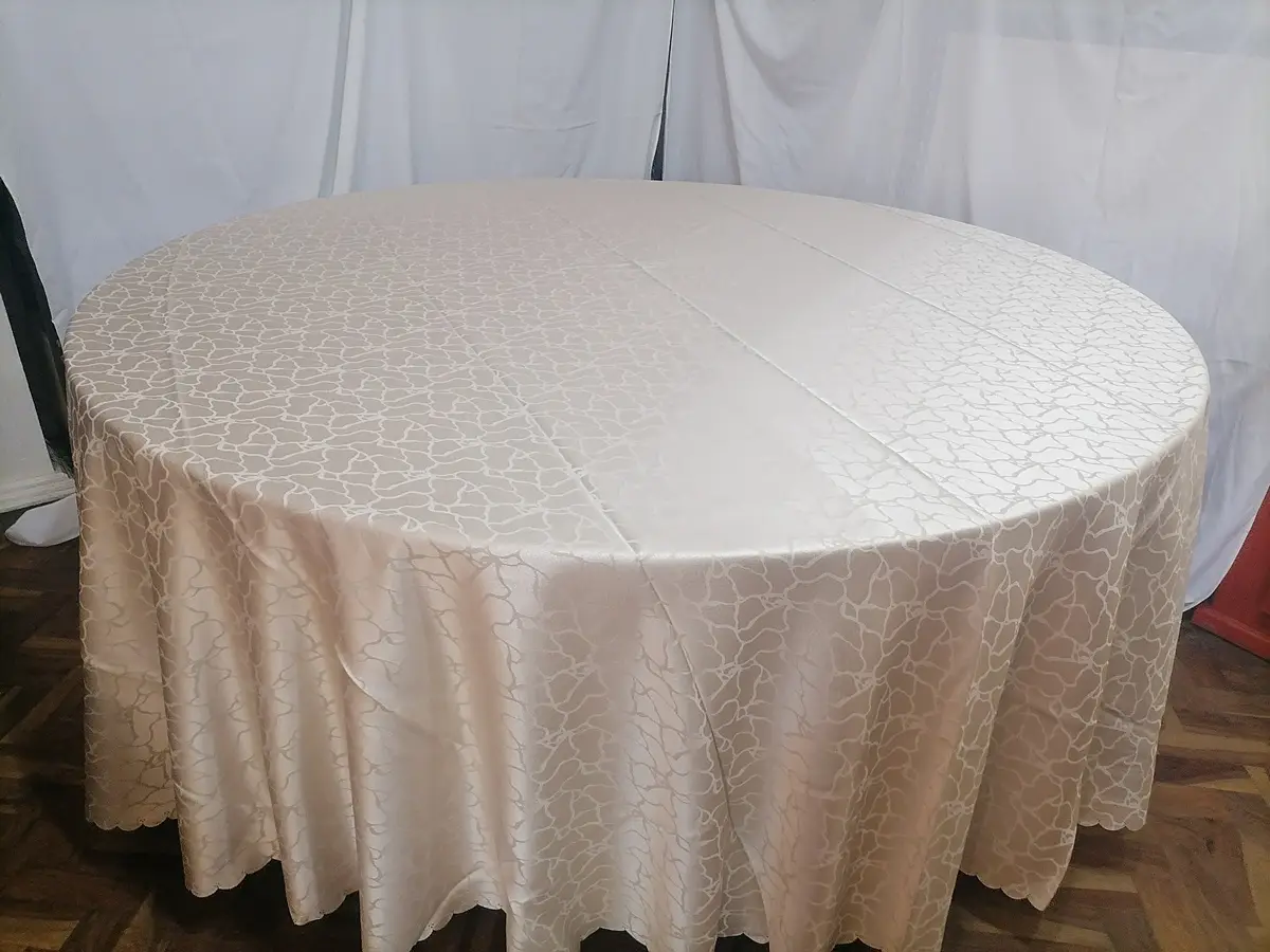 A round table in a champagne damask cloth